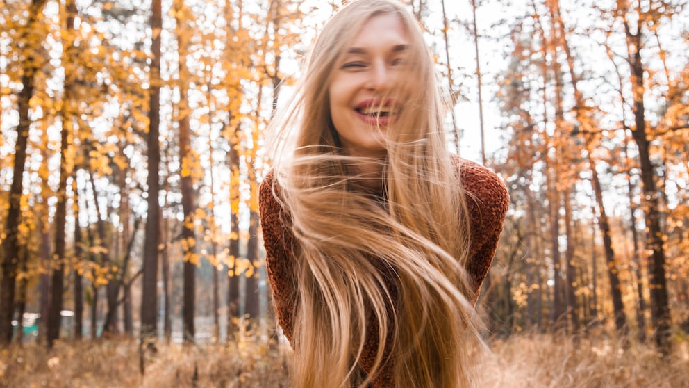 Frau mit langem blonden Haar, die bestimmt Biotin einnimmt