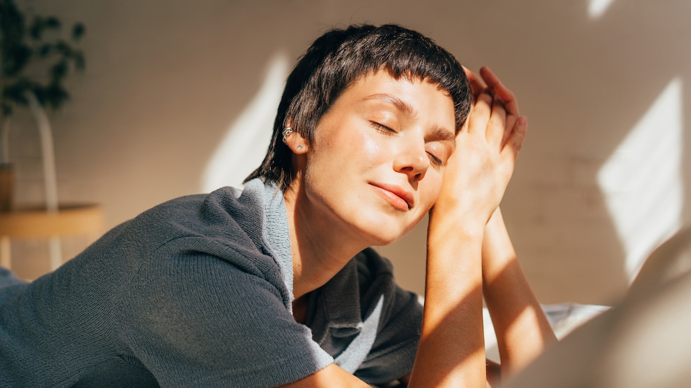 Frau liegend in der Sonne, sie sieht entspannt aus, als wären ihre Hormone im Gleichgewcht