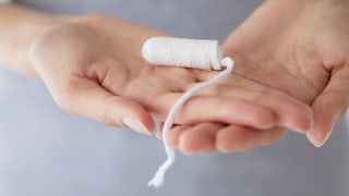 Frauenhände halten Tampon, der ein probiotischer Tampon sein könnte