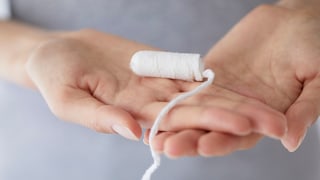 Frauenhände halten Tampon, der ein probiotischer Tampon sein könnte