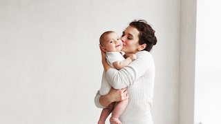 Frau hält Baby, das sehr süß guckt. Von Schwangerschaftsakne ist hier nichts zu sehen, aber es gibt auch keine passenden Fotos dazu. Dann doch lieber das süße Happy-Baby als Erinnerung, wofür frau das alles durchmacht. Respect, Ladies!