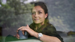 Frau mit Tasse Tee auf dem Sofa. Hilft bestimmt in den Wechseljahren. Und auch so. Eine Tasse Tee tut immer gut, oder?