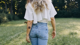 Frau mit feinem Tattoo am Arm