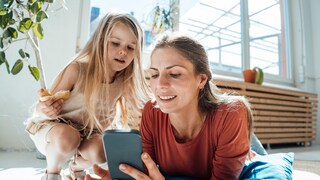 Mutter und Tochter scrollen durchs Handy