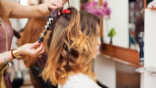 Frau mit Lockenstab im Haar