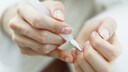 Jemand entfernt die Nagelhaut mit einem Nagelhautentferner