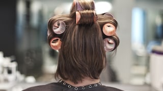 Frau von hinten mit Lockenwicklern in den Haaren