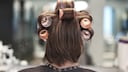 Frau von hinten mit Lockenwicklern in den Haaren