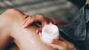 Frau cremt sich wahrscheinlich mit Bodylotion ein