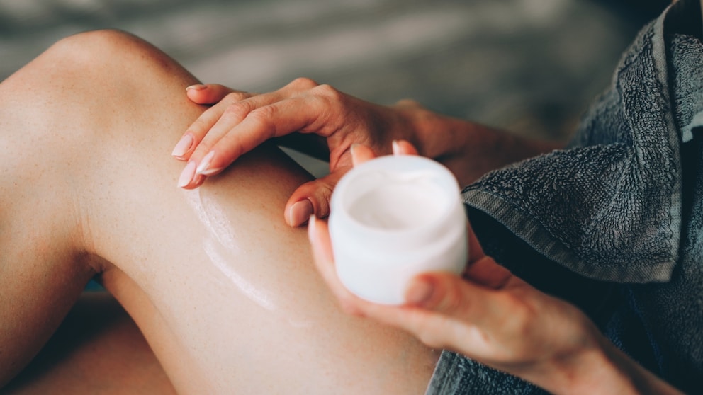 Frau cremt sich wahrscheinlich mit Bodylotion ein