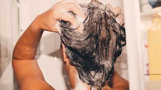 Frau wäscht sich die Haare vielleicht mit Olaplex-Produkten