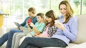 Familie sitzt auf dem Sofa und jeder ein Handy in der Hand