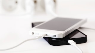 Zwei Handys stecken am Kabel und werden geladen