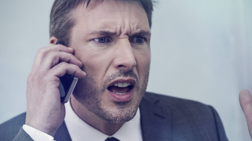 Mann telefoniert wütend am Smartphones