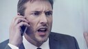 Mann telefoniert wütend am Smartphones