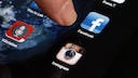 Ein Finger, der auf Smartphone-Apps zeigt