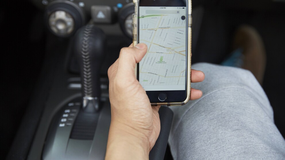 Mann hat Smartphone mit Navigations-Karte in der Hand