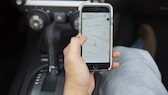 Mann hat Smartphone mit Navigations-Karte in der Hand