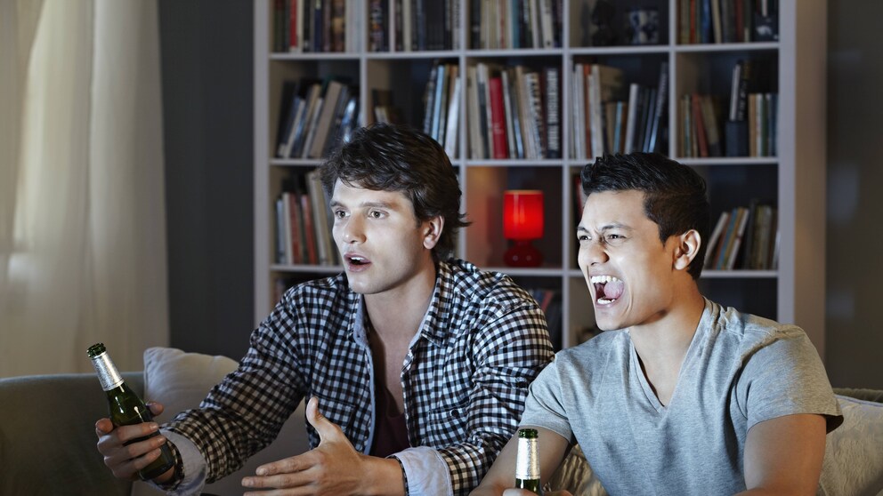 Zwei Männer sitzen wütend vor dem Fernseher