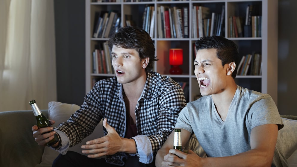 Zwei Männer sitzen wütend vor dem Fernseher