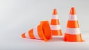 Drei Verkehrskegel vor einem weißen Hintergrund