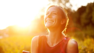 Sonne scheint auf Frau mit Smartphone