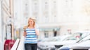Frau läuft auf der Straße und schaut dabei auf ihr Handy.