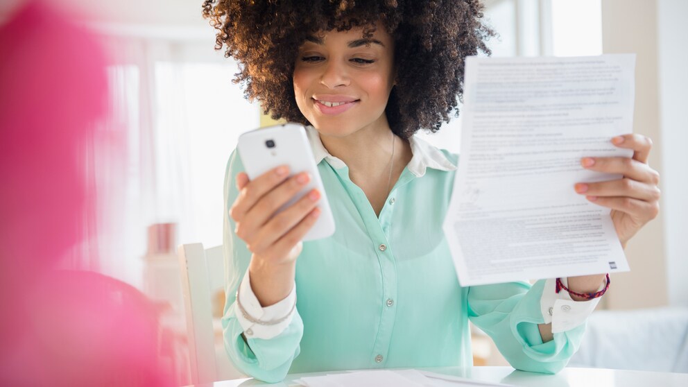 Frau mit Smartphone und Handy-Rechnung