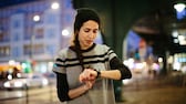 Woman checking her smart watch in city