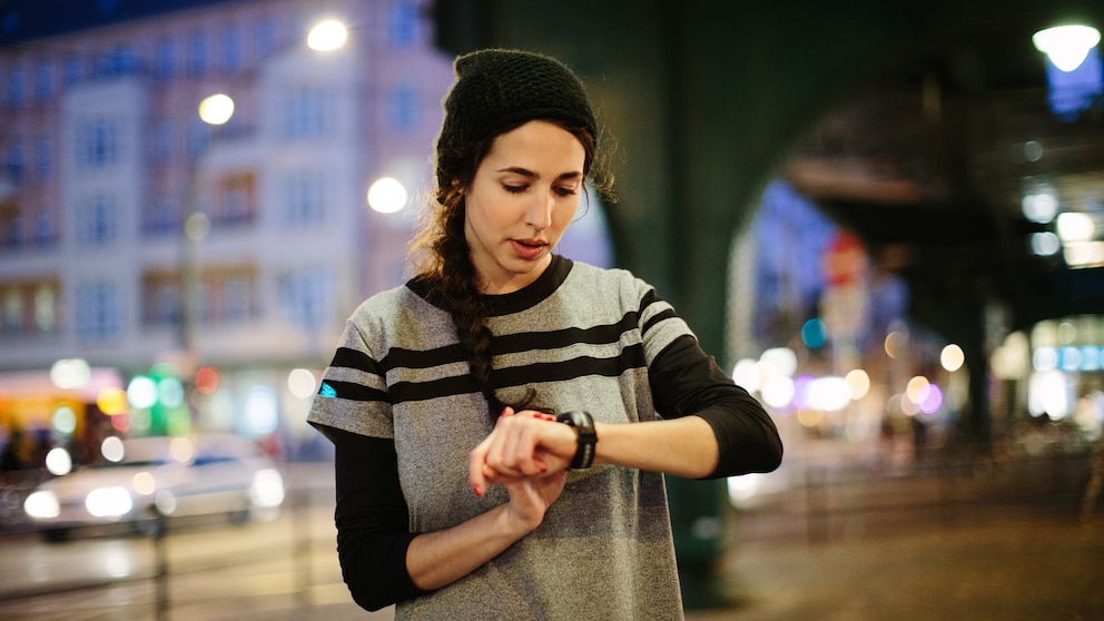 Woman checking her smart watch in city