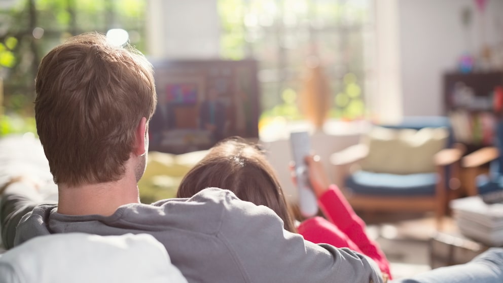 Pärchen schmusend vor dem Fernseher