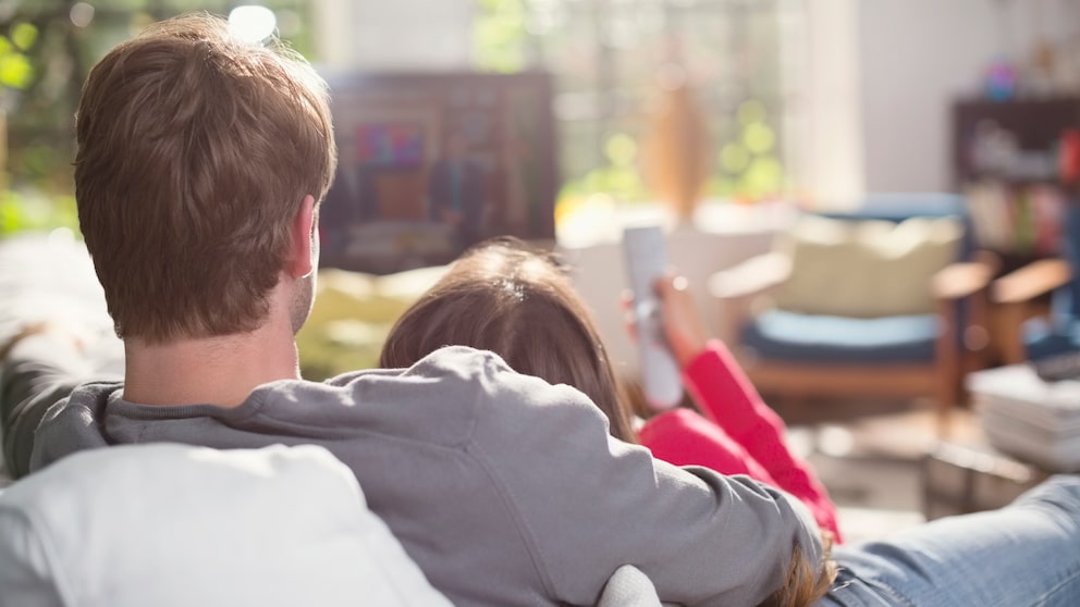 Pärchen schmusend vor dem Fernseher