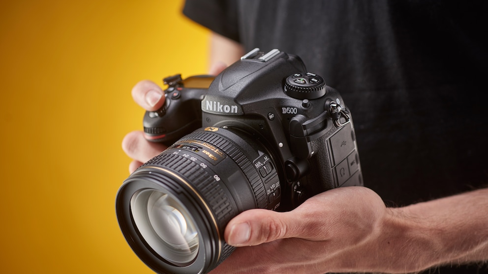 Mann hält Nikon Systemkamera