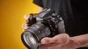 Mann hält Nikon Systemkamera
