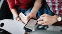 Paar hält Smartphone mit Navigations-App