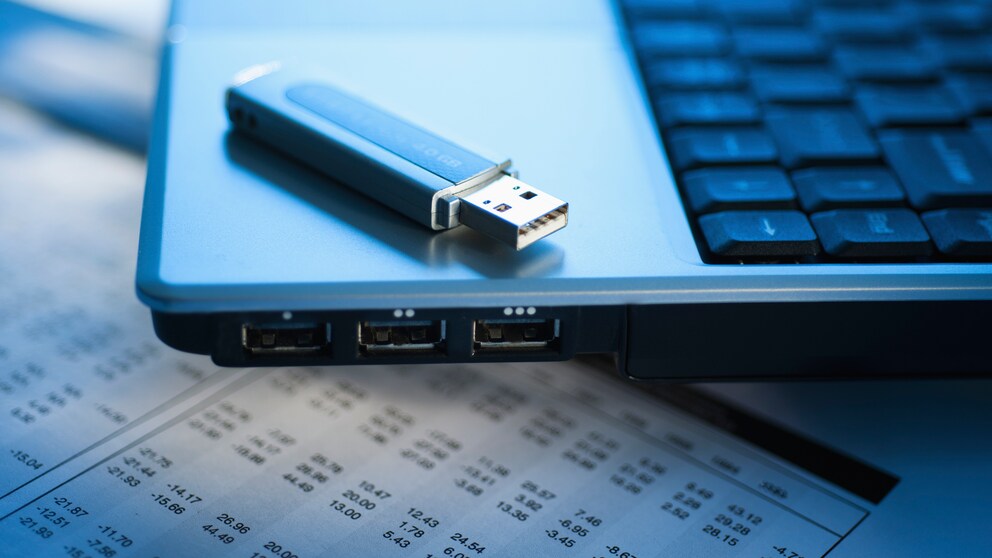 USB-Stick liegt auf einem Laptop mit USB-Buchsen