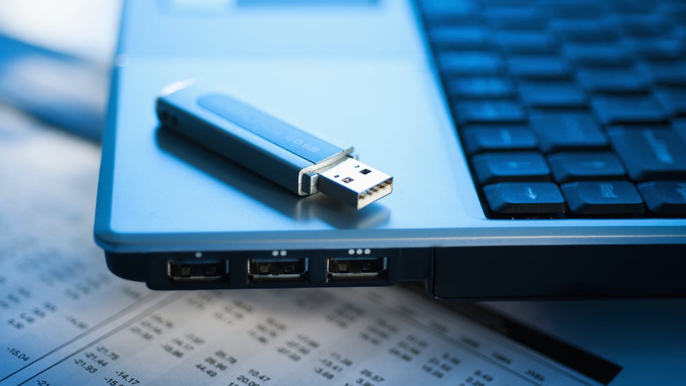 USB-Stick liegt auf einem Laptop mit USB-Buchsen