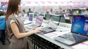 Frau bedient Laptop im Technik-Geschäft
