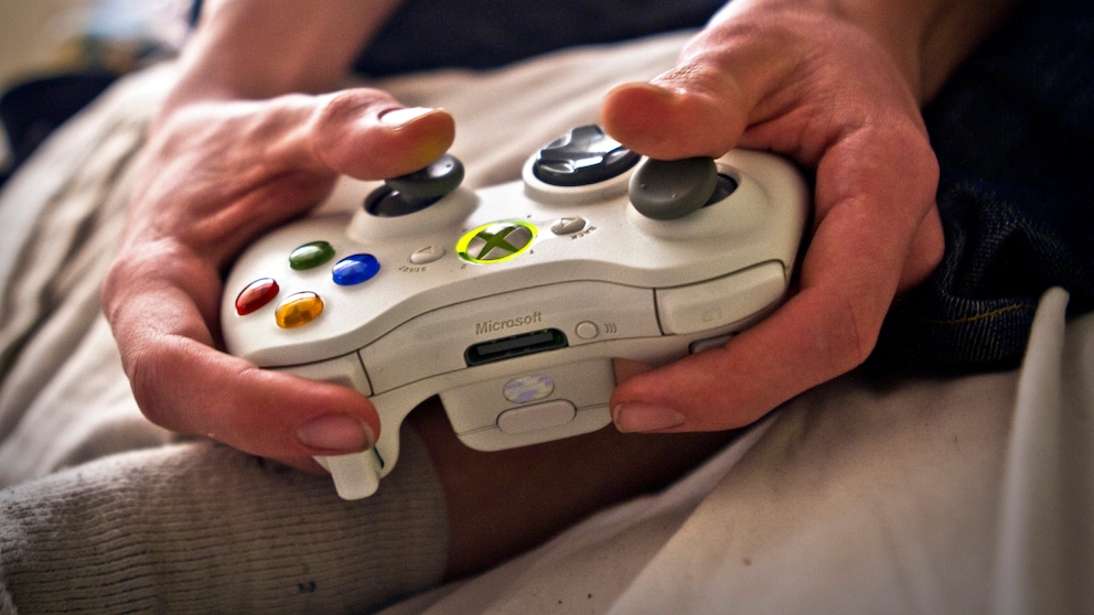 Mann hält einen Xbox-Controller in der Hand