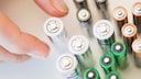 Hand greift nach Batterien