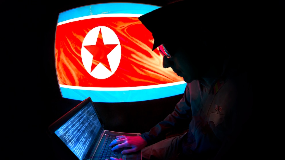 Silhoutte eines nordkoranischen Hackers mit einer nordkoreanischen Flagge im Hintergrund
