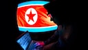 Silhoutte eines nordkoranischen Hackers mit einer nordkoreanischen Flagge im Hintergrund