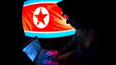 Silhoutte eines nordkoranischen Hackers mit einer nordkoreanischen Flagge im Hintergrund