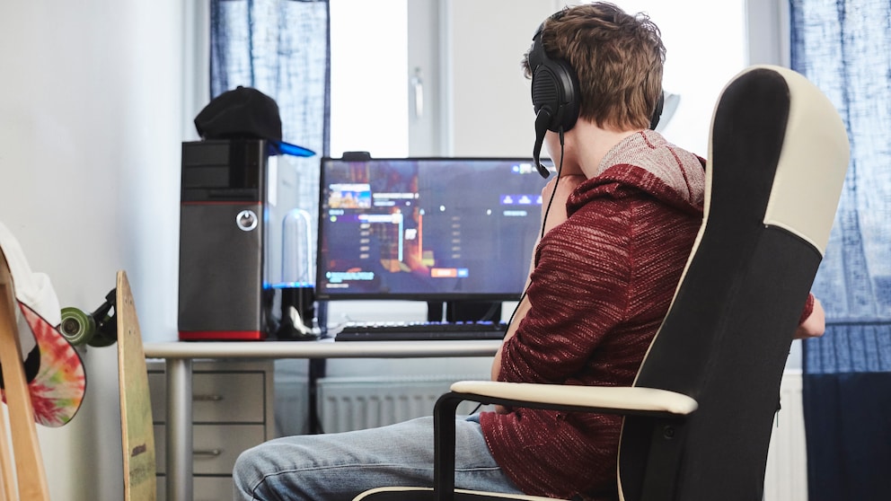 Junge sitzt vorm Rechner und spielt ein PC-Spiel