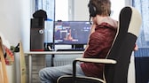 Junge sitzt vorm Rechner und spielt ein PC-Spiel