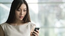 Frau schaut schockiert aufs Handy