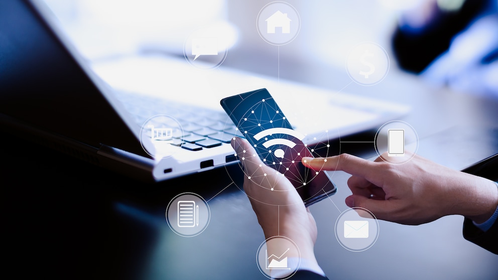 Smartphone und Laptop mit visualisierter Drahtlosverbindung