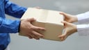 Zusteller liefert Paket aus