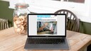 Laptop mit Webseite und Keksen auf einem Holztisch