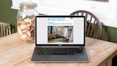 Laptop mit Webseite und Keksen auf einem Holztisch